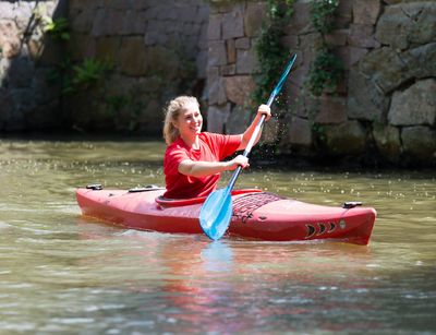 Eine Studentin fährt im Kanu auf einem Fluss