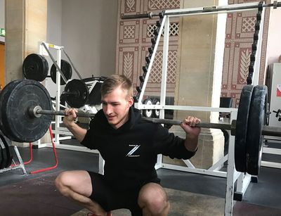 Ein Student hebt Gewichte in der nostaligischen Krafthalle in Leipzig