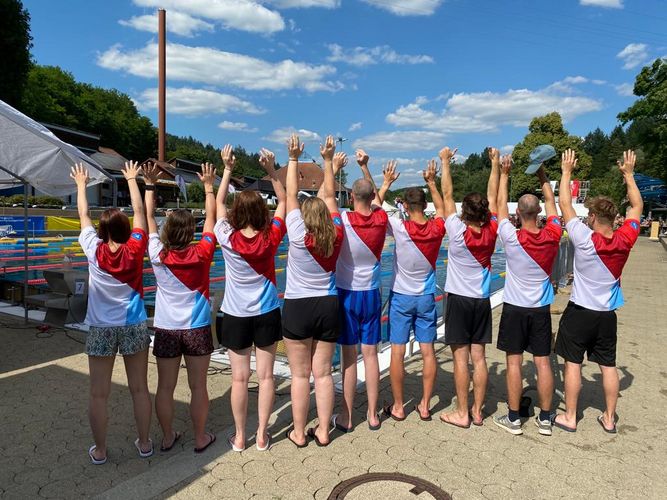 Man sieht die Rückenansicht einer Mannschaft, die bei den DHM Schwimmen teilgenommen haben.