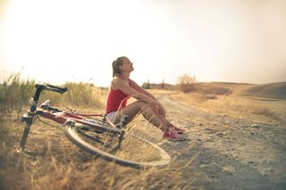 Eine Radfahrerin macht eine Pause im Sonnenuntergang
