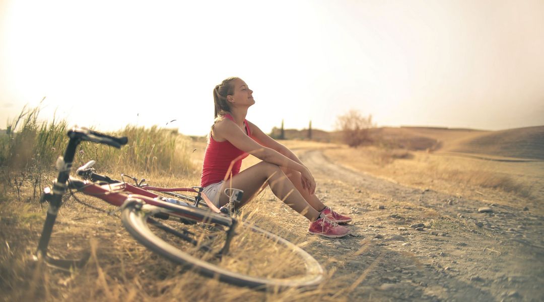 Eine Radfahrerin macht eine Pause im Sonnenuntergang